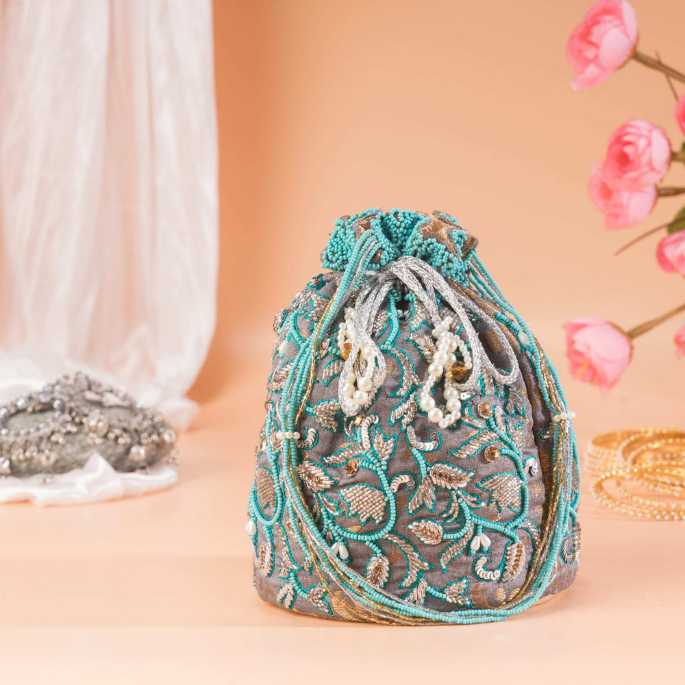 Beaded drawstring cords and pearl tassels at the gathered mouth of the potli