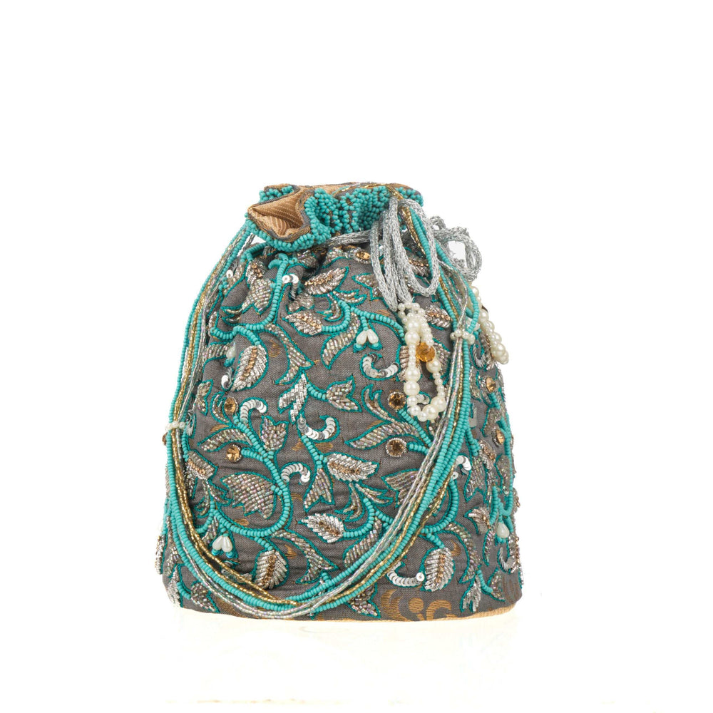 Potli bag on white, turquoise bead vines winding over the slate grey brocade