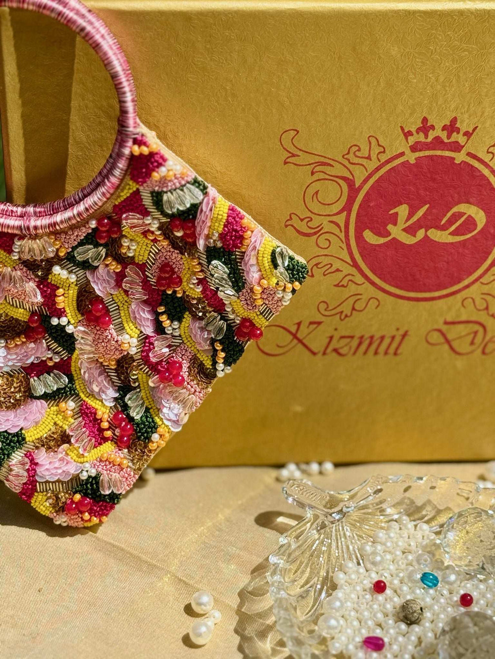 Close-up of raised floral threadwork and bead clusters across the front of the clutch